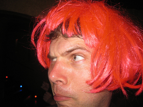 A man wearing a red wig